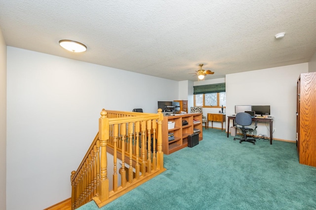 carpeted office space featuring ceiling fan and a textured ceiling