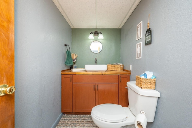 bathroom featuring vanity, a textured ceiling, toilet, and tile patterned flooring