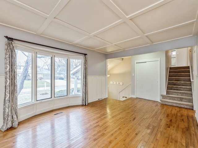 unfurnished living room featuring wood-type flooring and coffered ceiling