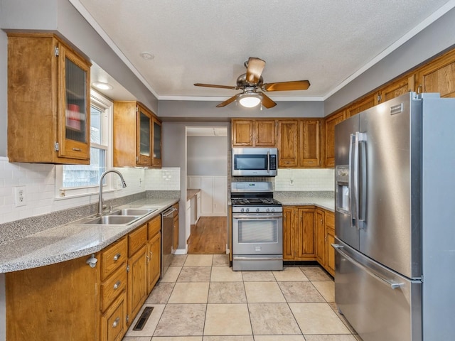 kitchen featuring decorative backsplash, appliances with stainless steel finishes, ceiling fan, sink, and light tile patterned floors