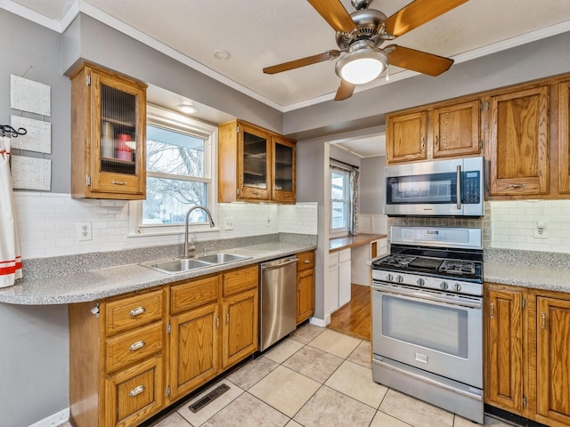 kitchen featuring sink, ornamental molding, stainless steel appliances, and light tile patterned floors