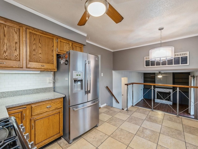 kitchen featuring stove, crown molding, stainless steel refrigerator with ice dispenser, light tile patterned floors, and decorative light fixtures