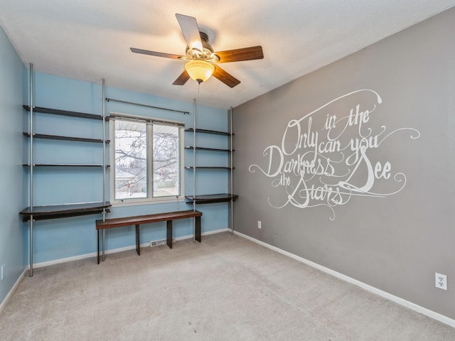 carpeted spare room with ceiling fan and a textured ceiling