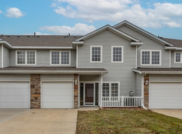 view of property featuring a garage and a front yard