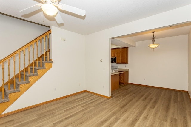 unfurnished living room featuring ceiling fan and light hardwood / wood-style flooring