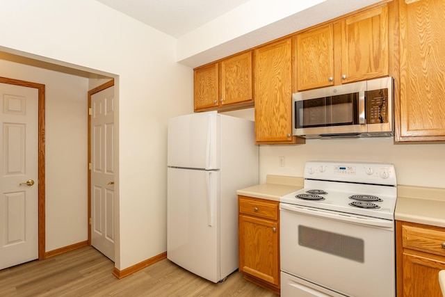 kitchen with white appliances and light hardwood / wood-style floors