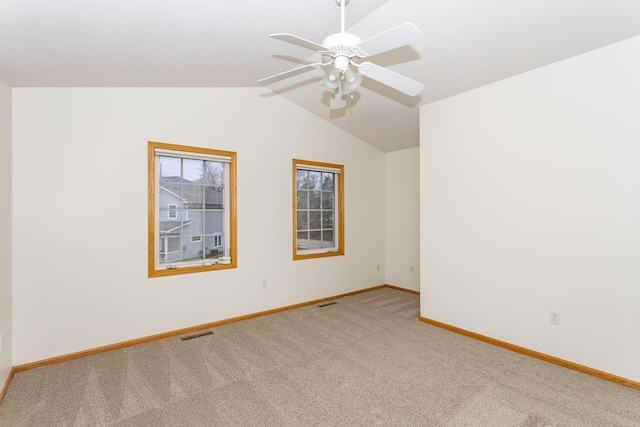 carpeted empty room featuring ceiling fan and vaulted ceiling