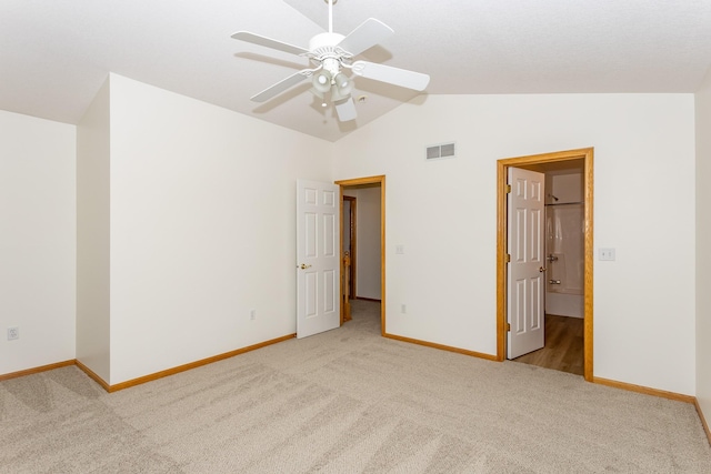 unfurnished bedroom with ceiling fan, lofted ceiling, ensuite bathroom, and light colored carpet