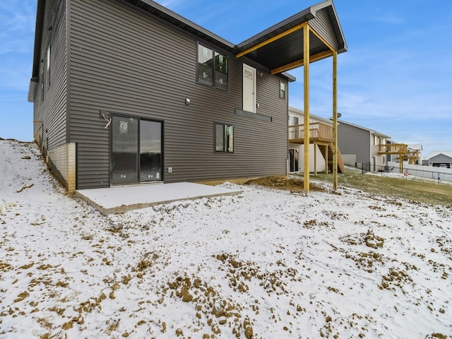 snow covered property featuring a wooden deck