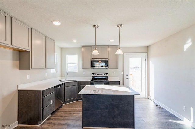 kitchen featuring pendant lighting, sink, gray cabinets, appliances with stainless steel finishes, and a center island