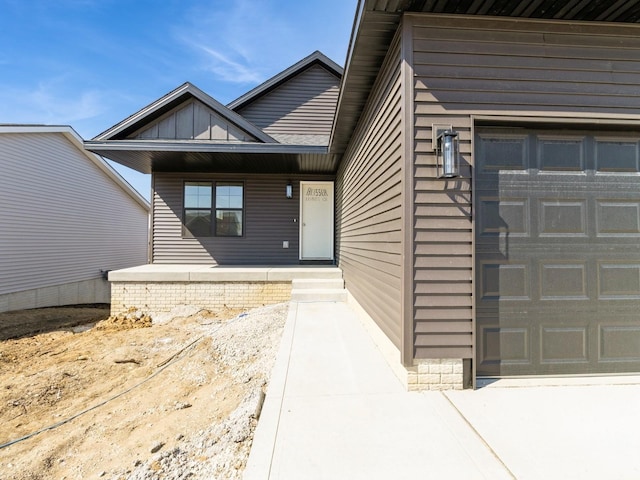 entrance to property with an attached garage and covered porch