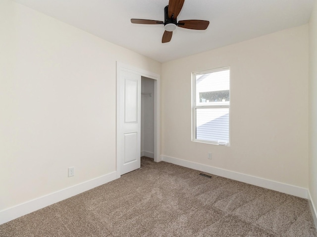 unfurnished bedroom with visible vents, baseboards, light colored carpet, a closet, and ceiling fan