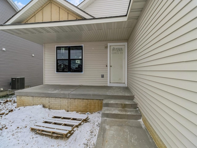 snow covered property entrance with central AC