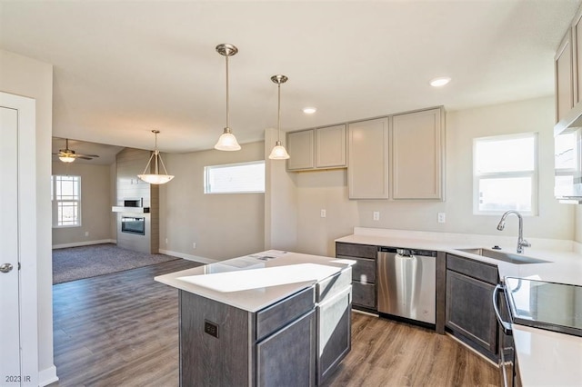 kitchen with sink, hanging light fixtures, appliances with stainless steel finishes, plenty of natural light, and a kitchen island