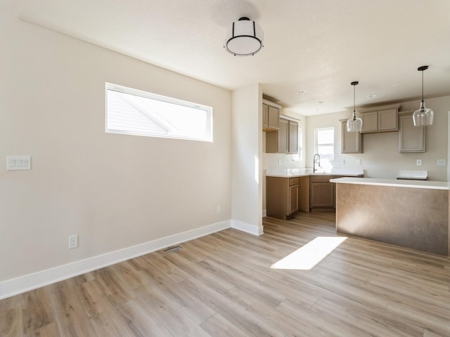 201 S Valley View Dr, Norwalk, IA 50211 - kitchen with a sink, light wood-type flooring, baseboards, pendant lighting, and light countertops
