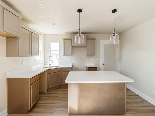 201 S Valley View Dr, Norwalk, IA 50211 - kitchen featuring a sink, a kitchen island, light wood-type flooring, baseboards, and pendant lighting