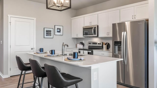 kitchen with a sink, white cabinetry, light countertops, appliances with stainless steel finishes, and tasteful backsplash