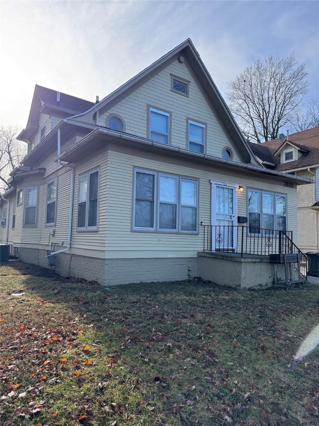 back of house featuring a yard and central air condition unit