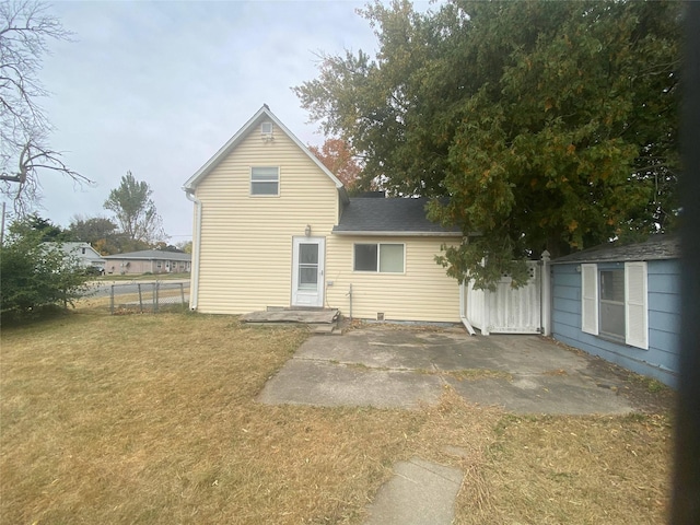 back of house with a patio and a lawn