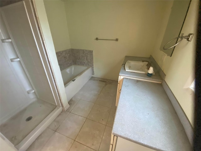 bathroom featuring tile patterned flooring, shower with separate bathtub, and sink