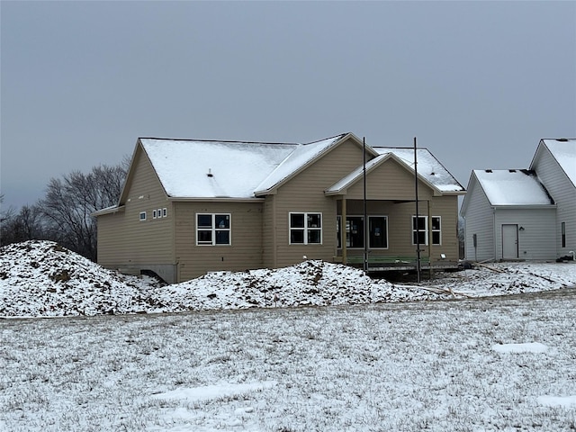 view of snow covered back of property