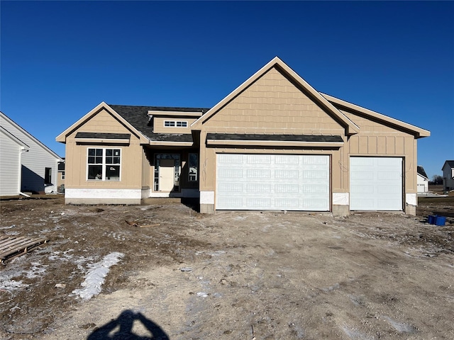 view of front of property featuring an attached garage, board and batten siding, and roof with shingles