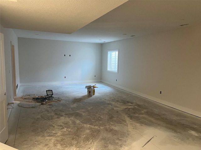 empty room featuring baseboards and a textured ceiling