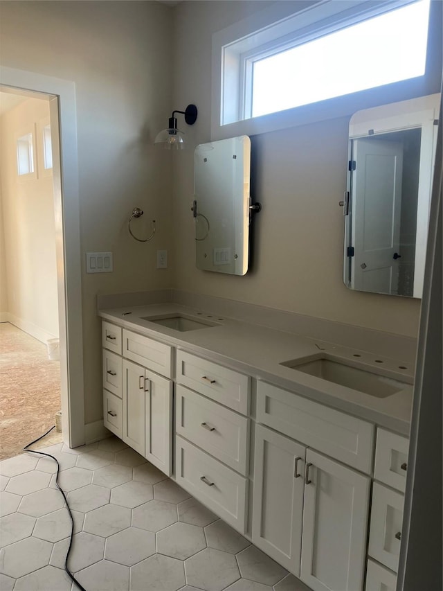 bathroom featuring water heater, double vanity, and a sink