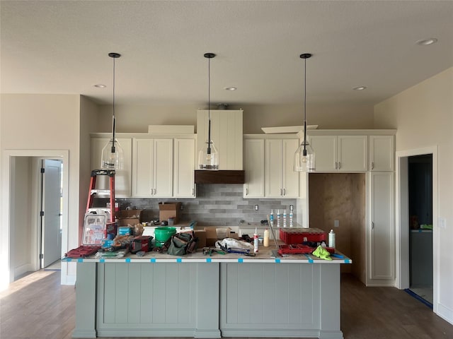 kitchen with tasteful backsplash, a center island, and white cabinetry