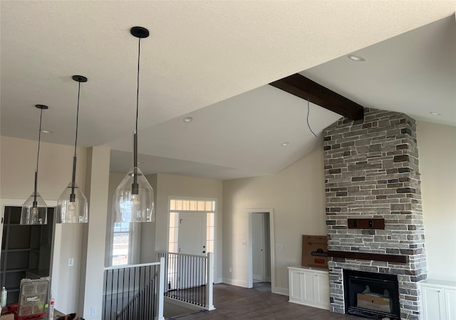 unfurnished living room with wood finished floors, baseboards, high vaulted ceiling, a fireplace, and beamed ceiling