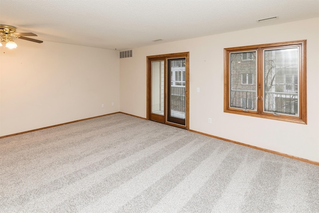 carpeted spare room featuring ceiling fan