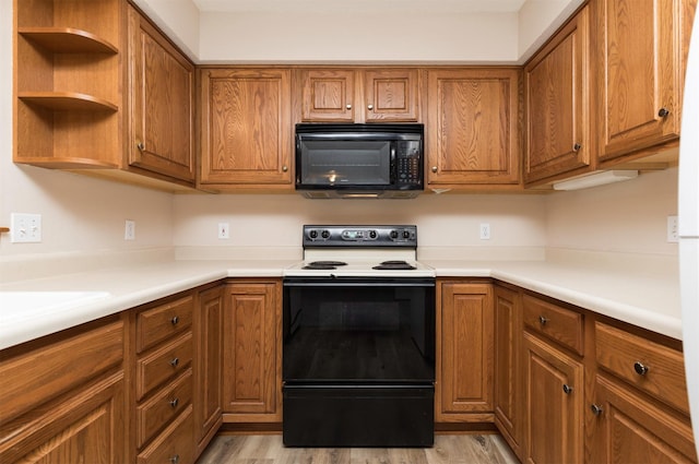 kitchen with light hardwood / wood-style floors and black appliances