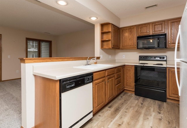 kitchen with kitchen peninsula, light wood-type flooring, white appliances, and sink