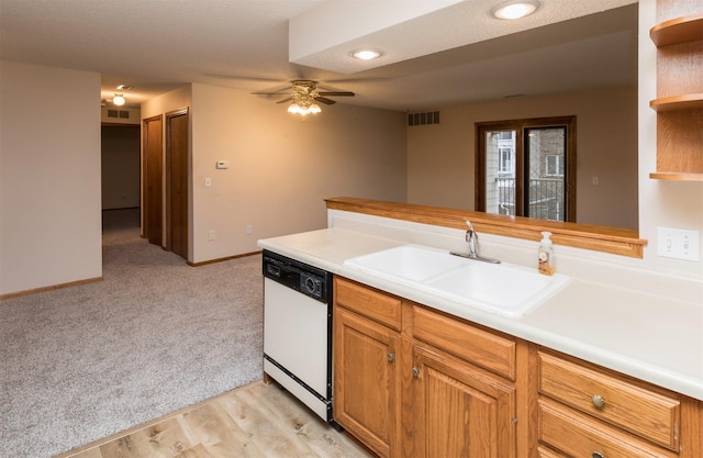 kitchen featuring light carpet, kitchen peninsula, ceiling fan, sink, and dishwasher