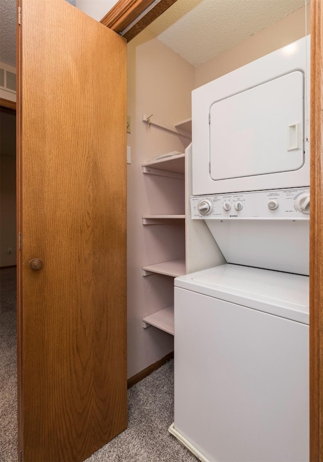 washroom with carpet flooring, a textured ceiling, and stacked washer and clothes dryer