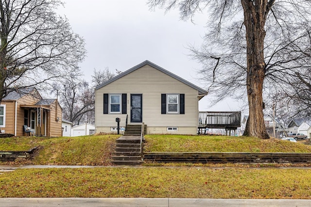 bungalow featuring a front yard and a deck