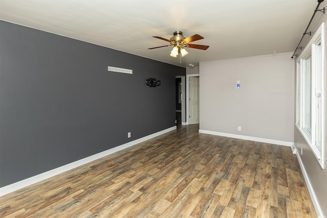 spare room featuring ceiling fan, plenty of natural light, and dark wood-type flooring