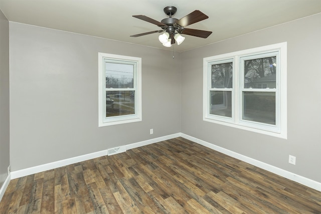 empty room with dark hardwood / wood-style flooring and ceiling fan