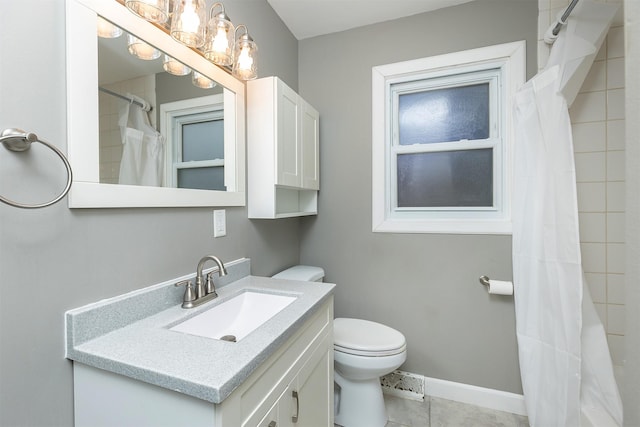 bathroom with tile patterned floors, vanity, toilet, and walk in shower