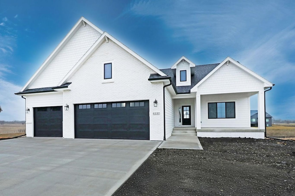 modern farmhouse featuring a porch and a garage