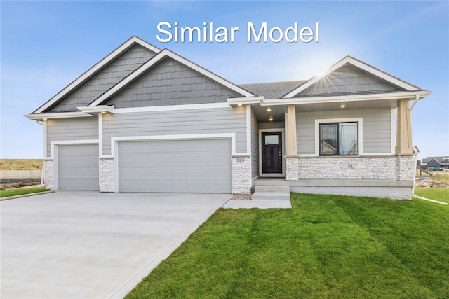 craftsman inspired home featuring a garage and a front lawn