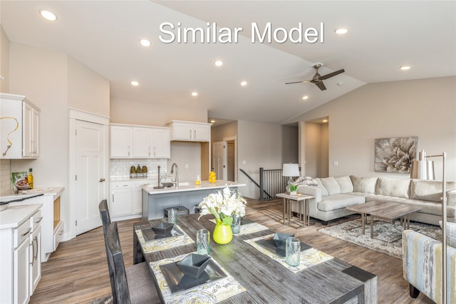 living room featuring ceiling fan, wood-type flooring, and vaulted ceiling