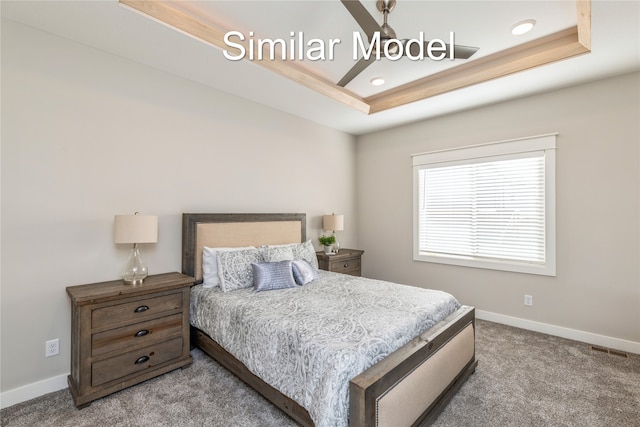 bedroom with a raised ceiling and light colored carpet