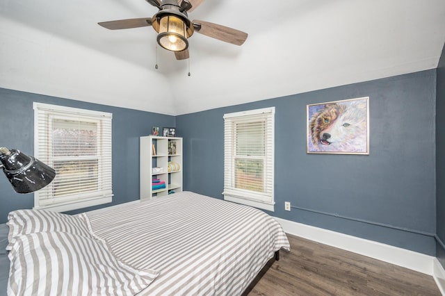 bedroom featuring ceiling fan, dark hardwood / wood-style flooring, and vaulted ceiling