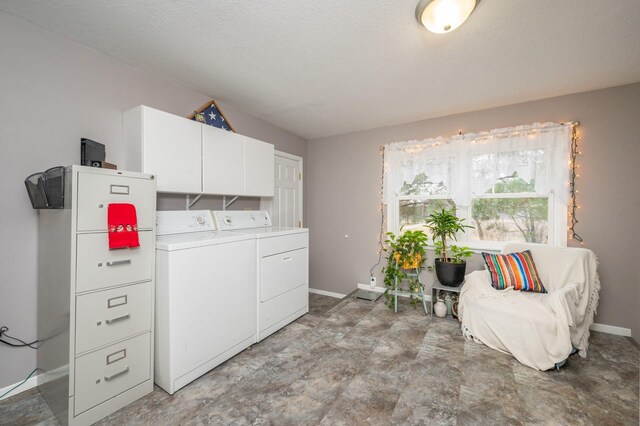 laundry room featuring cabinets, separate washer and dryer, and a textured ceiling