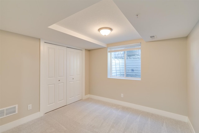 unfurnished bedroom featuring light carpet and a closet