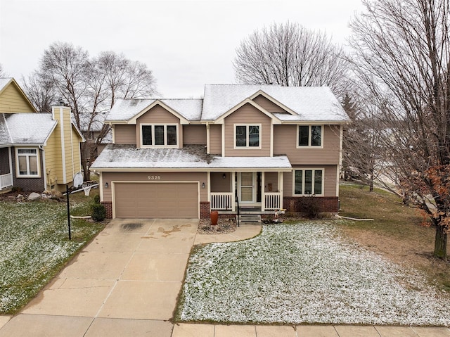 view of front of property featuring covered porch, a garage, and a front lawn