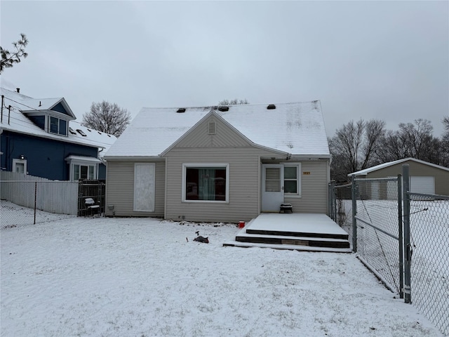 snow covered property featuring a wooden deck and an outbuilding