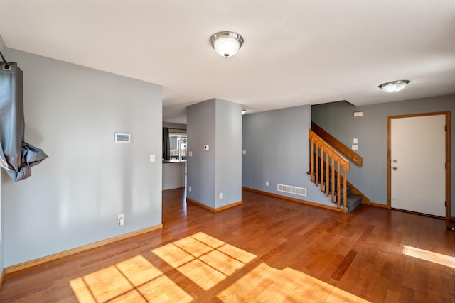 interior space featuring visible vents, stairway, baseboards, and wood finished floors