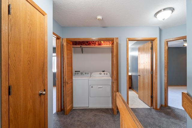 laundry area with washer and dryer, laundry area, dark colored carpet, and a textured ceiling